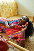 Laughing on a red retro telephone, lying on a rug in the Summer Stripe Grace Top and Wide Leg Pants
