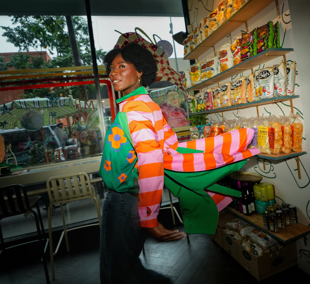 Person wearing a colorful sweater in a store with shelves and products.